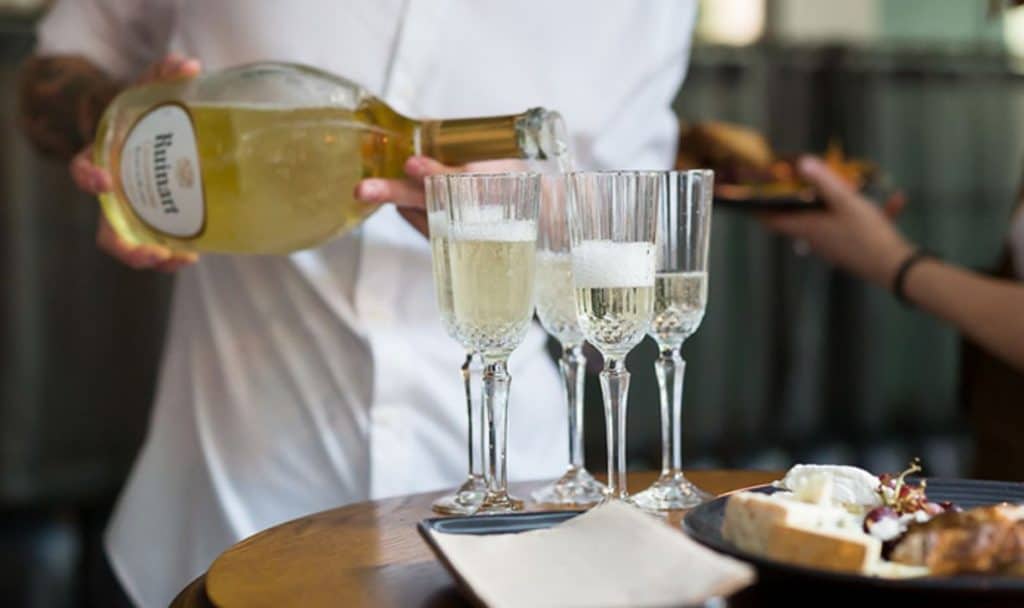 glasses of champagne being poured by waiter