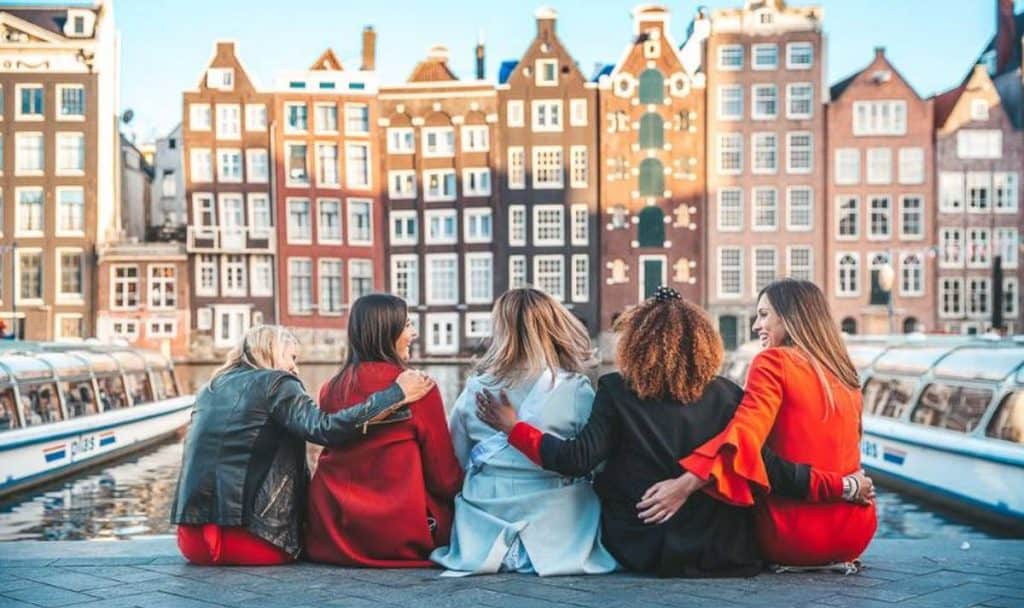 girls in amsterdam sitting in front of buildings