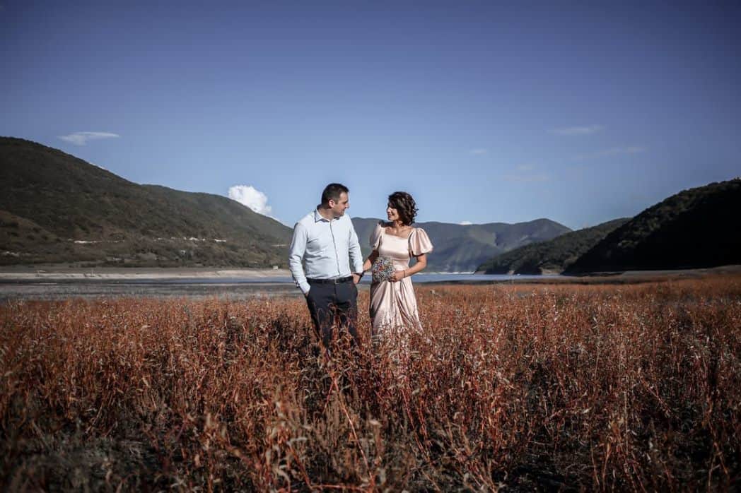 romantic elegant couple in valley with mountains ·