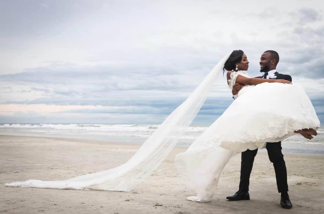 bride and groom kissing on beach during daytime ph