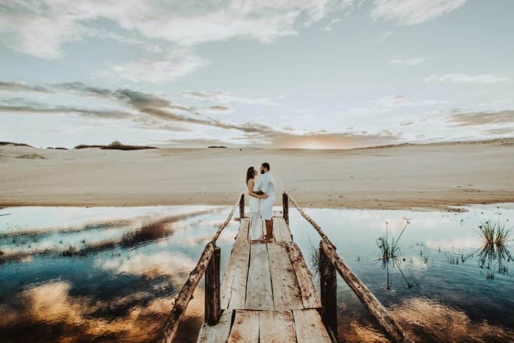 couple face each other on brown wooden dock photo