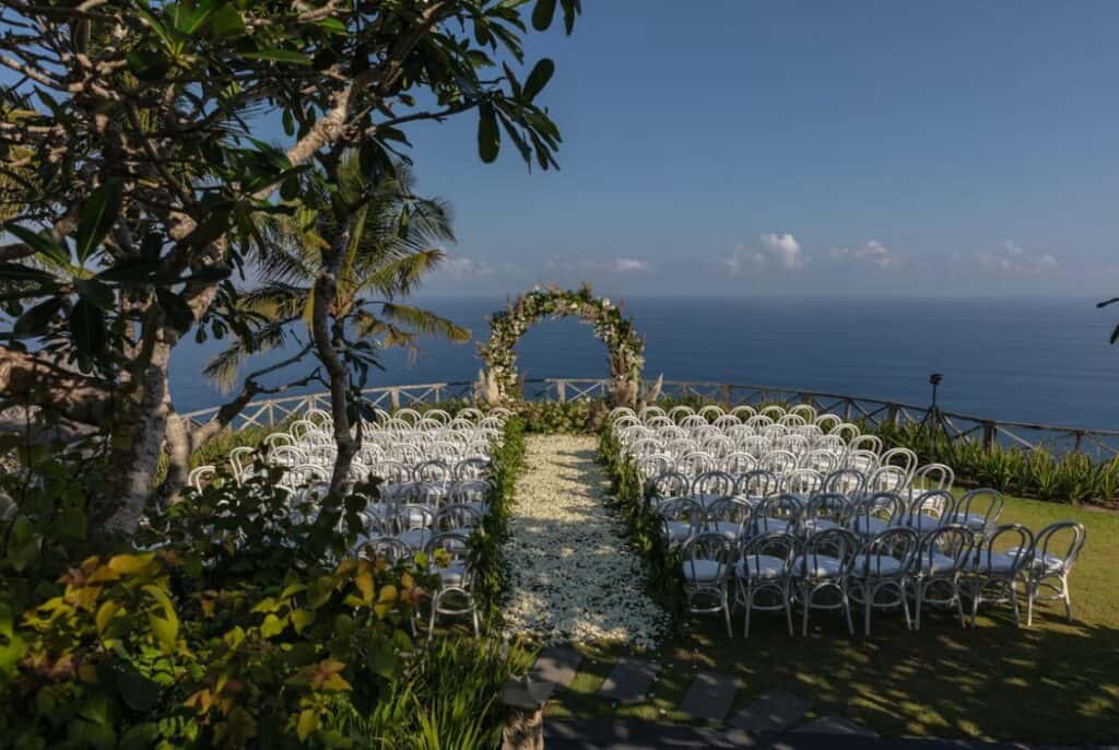 white chairs and green and white floral arch photo
